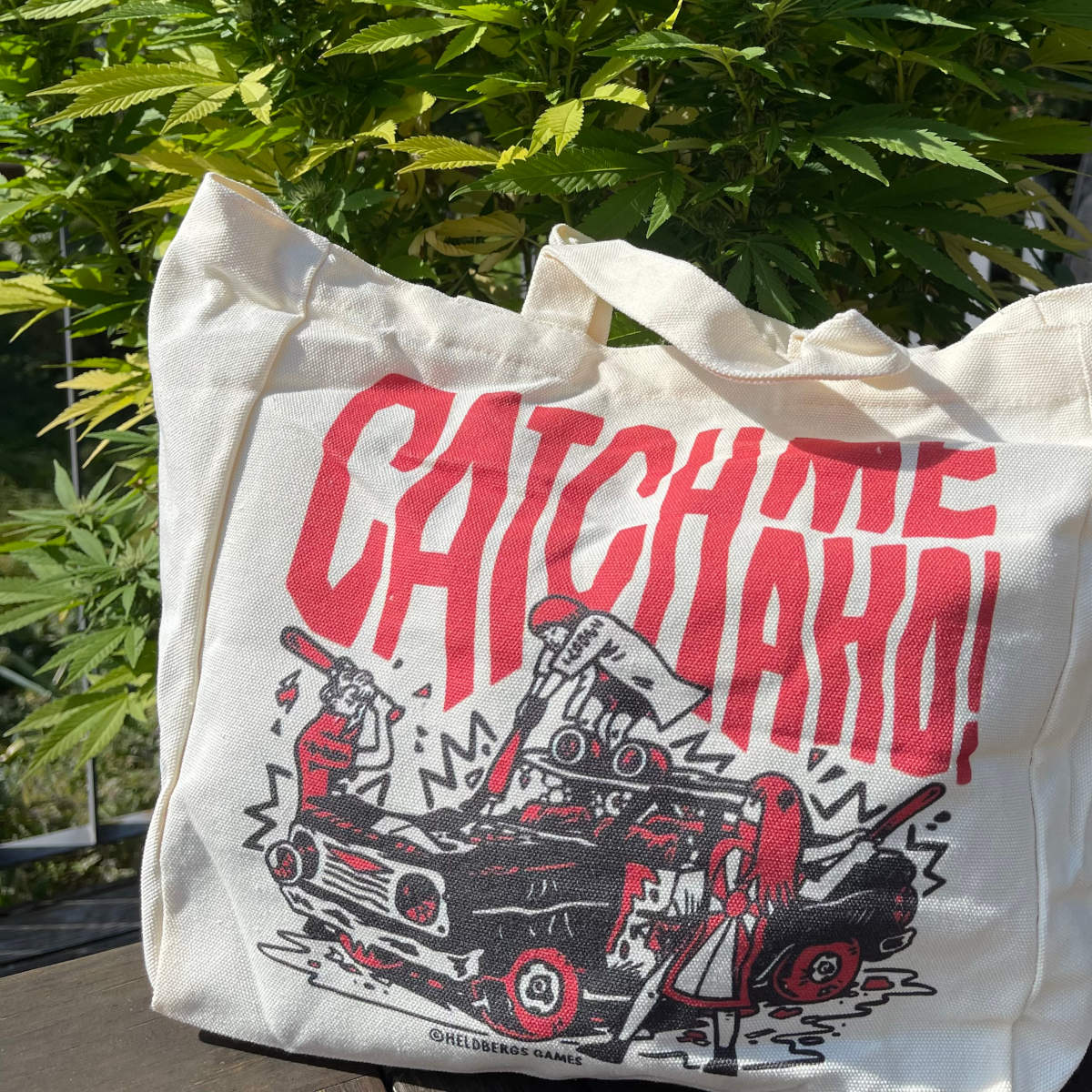 „Catch me Aho“ Tote Bag von Heldbergs Games, inspiriert von Sukeban-Kultur. Hergestellt aus 16-Unzen-Baumwolle, Maße 32 x 33 x 16 cm, mit Magnetverschluss und Innentasche. Frecher Style für Abenteuer.