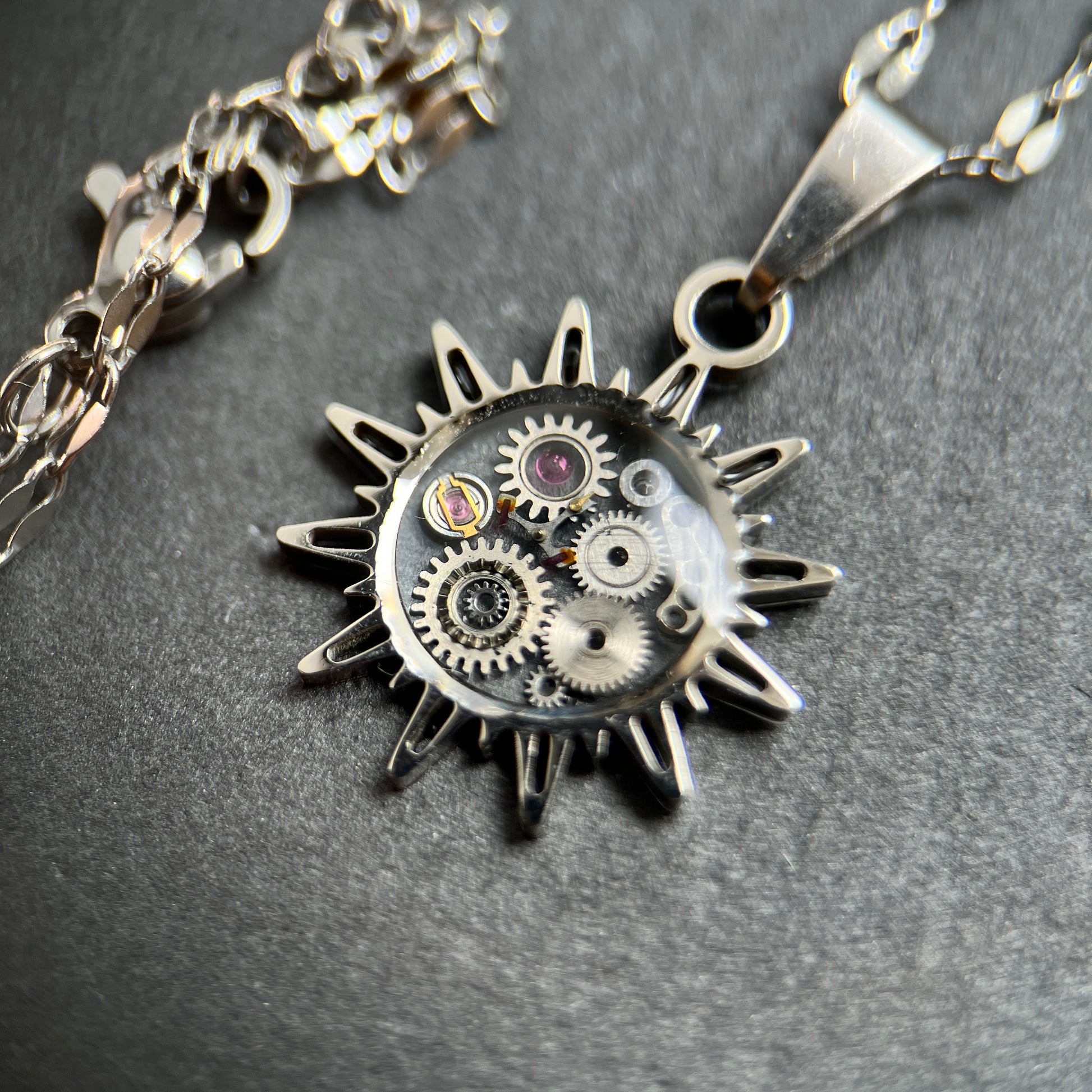 WatchThis „Sol“ handgemachte Halskette – Sonnenförmiger Anhänger aus alten Uhren, 18k vergoldet oder Silber mit Edelstahl. Kettenlänge 44 cm, Anhängergröße 2 cm. Dreizack Wien.