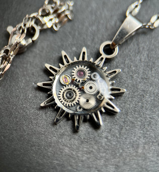 WatchThis „Sol“ handgemachte Halskette – Sonnenförmiger Anhänger aus alten Uhren, 18k vergoldet oder Silber mit Edelstahl. Kettenlänge 44 cm, Anhängergröße 2 cm. Dreizack Wien.