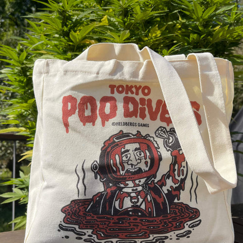 „Tokyo Poo Divers“ Tote Bag von Heldbergs Games, aus 16-Unzen-Baumwolle. Maße 32 x 33 x 16 cm, mit Magnetverschluss und Innentasche. Freches Design für urbane Legenden.