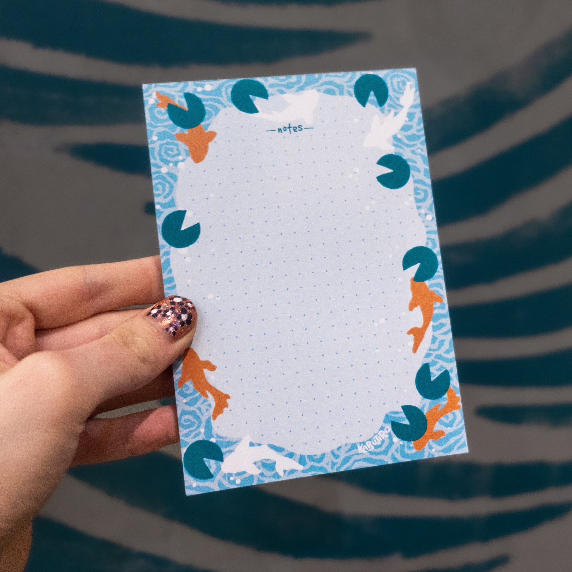 Koi Pond A6 Notizblock – Eleganter Notizblock mit Koi-Fisch- und Wasserlilien-Motiven, A6-Format, 50 gepunktete Seiten, 80gsm Papier. Dreizack Wien.