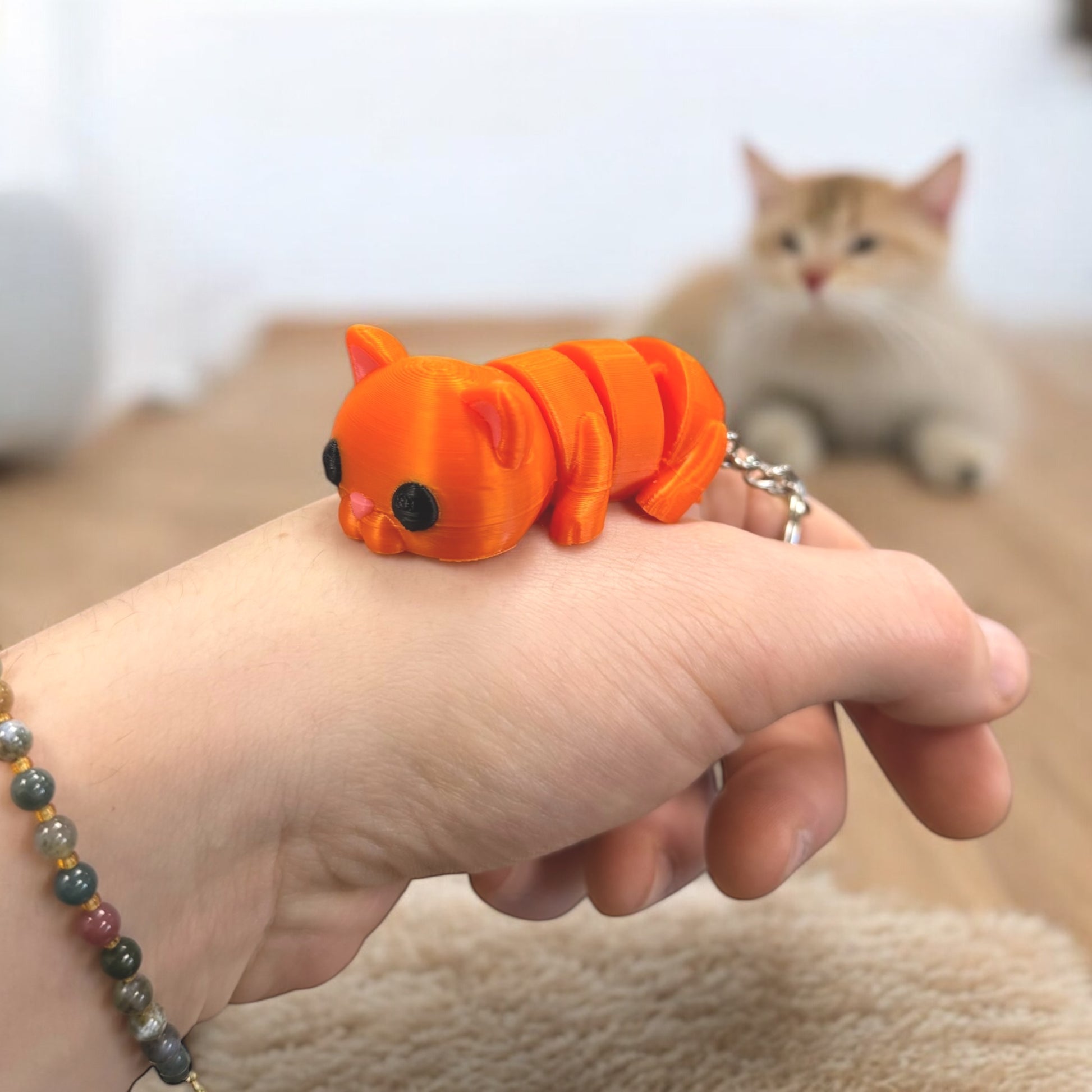 Schlüsselanhänger "Flexi-Katze" von Dreizack 3D-Druck: Bewegliche Katze aus nachhaltigem PLA in Farben wie Orange, Spacekitty (Blau-Violett-Verlauf) oder Marmor-Weiß, mit Edelstahl-Anhänger. Handgefertigt in Wien.