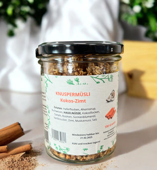 Knuspermüsli Kokos-Zimt – Knusprige Mischung aus Haferflocken, Kokosflocken, Nüssen und Früchten, verfeinert mit Zimt und Muskat. Perfekt für ein leckeres und gesundes Frühstück, 180 g Glas.