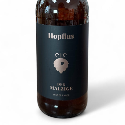 Der Malzige von Hopfius: Wiener Lager mit bernsteinfarbener Optik, malzigem Karamellaroma und milder Bittere. Prämiertes Craft-Bier aus Österreich – ein Geschmackserlebnis.