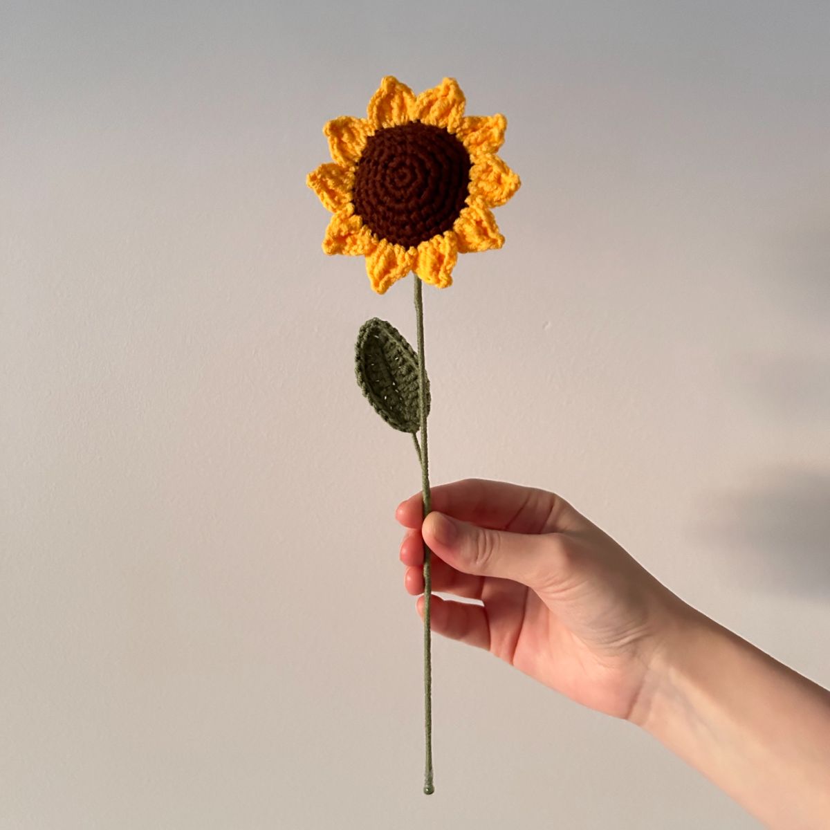 Handgehäkelte Sonnenblume mit Blättern, ca. 30 cm lang, aus hochwertigem Garn. Zeitlose Dekoration, verwelkt nie, ideal für Vasen oder als Geschenk. Über 20 Blumenarten verfügbar, perfekt für individuelle Sträuße.